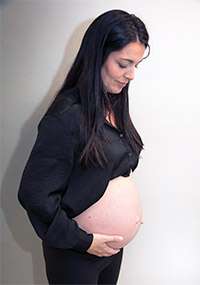 Gravid kvinde kigger på sin mave